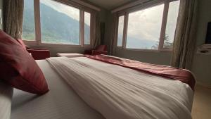 A bed or beds in a room at Hotel Ocean & Hotel Meadows Mountain View ! A Family Hotel ! Near To Mall Road