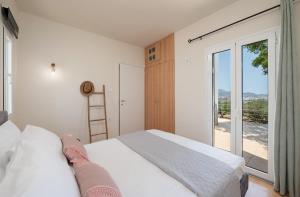 a bedroom with a bed and a large window at ALMA casa in Mardhátion