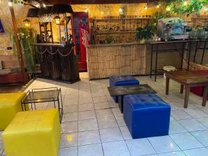 a restaurant with yellow and blue benches and tables at Enkanta Guest House in Trujillo
