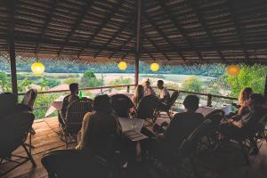 a group of people sitting at tables on a patio at The Bay Agonda in Agonda