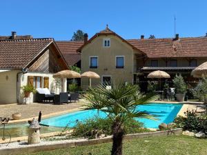 a villa with a swimming pool in front of a house at Auberge du Relais d'Auniac - Hôtel Bar Restaurant Bistronomique Piscine in Anglars-Nozac