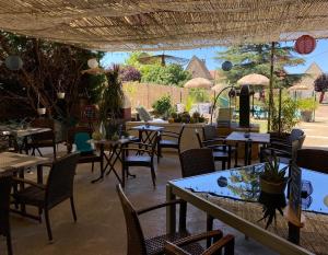 a restaurant with tables and chairs and a patio at Auberge du Relais d'Auniac - Hôtel Bar Restaurant Piscine in Anglars-Nozac
