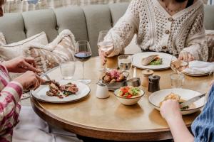 a group of people sitting around a table with plates of food at No 42 by GuestHouse, Margate in Margate