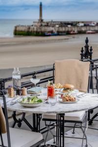 a table with plates of food on top of the beach at No 42 by GuestHouse, Margate in Margate