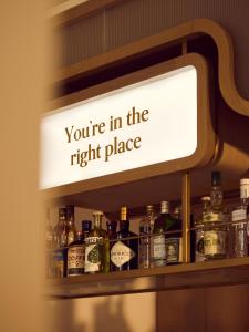 a sign that says youre in the right place on a shelf with bottles at No 42 by GuestHouse, Margate in Margate