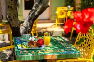 a table with a plate of food and a glass of orange juice at Hotel Les Oliviers in Draguignan