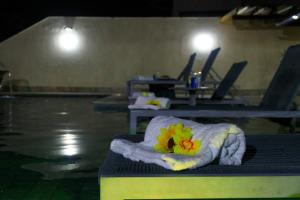 a towel with flowers on top of a swimming pool at PÉ NA AREIA, DE FRENTE PARA A PRAIA - Casa Paraíso dos Corais 8 suítes, Praia Guarajuba in Guarajuba