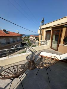 a patio with two chairs and a table on a balcony at Lajes Apartment in Skala Potamias