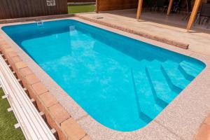 a swimming pool with blue water in a backyard at Tengercsillag Vendégház in Alsóörs