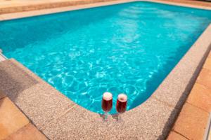 two pairs of flip flops standing next to a swimming pool at Tengercsillag Vendégház in Alsóörs