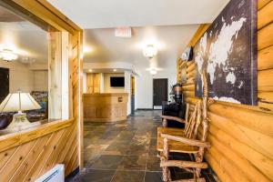 a living room with wooden walls and two chairs at Mountain Vista Hotel in West Yellowstone