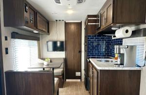 a small kitchen with wooden cabinets and a sink at La Gozadera Park RV Royal in Salinas