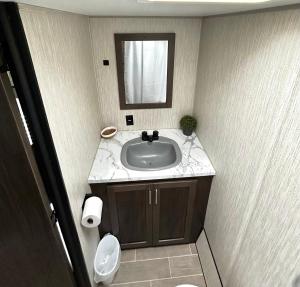 a bathroom with a sink and a mirror and a toilet at La Gozadera Park RV Royal in Salinas