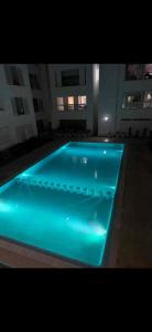 a swimming pool with blue lights in a building at Plage manesmann in Mohammedia +6 photos