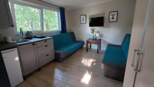 a living room with two blue chairs and a sink at Pirat Turawa in Turawa