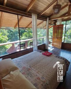 a bed in a room with a large window at Pungara Eco-Lodge in Tena