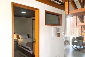 een slaapkamer met een bed en een tv aan de muur bij Perequê Center in Ilhabela