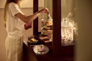 a woman putting food in a jar in a cabinet at No 42 by GuestHouse, Margate in Margate