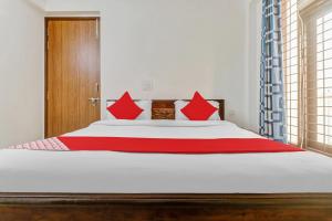 a bedroom with a large bed with red pillows at Hotel O South Plaza in New Delhi +18 photos