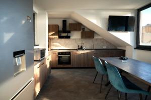a kitchen with a table and blue chairs in a room at Casa LaMal in Divici