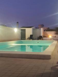 a swimming pool in front of a house at night at House Rita Marzamemi in Marzamemi