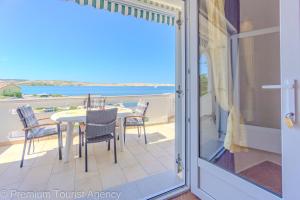 a balcony with a table and chairs and a view of the ocean at Rajka in Kustići