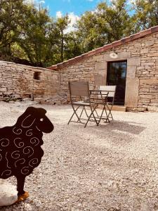 a statue of a sheep standing in front of a building at Mas de Méjas Gîte La Casaline in Calvignac
