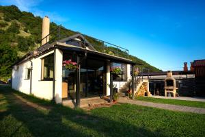 a small white building with flowers on the front at Casa LaMal in Divici