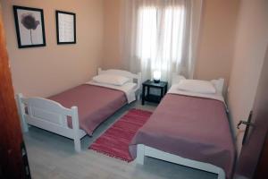 a bedroom with two beds and a window at Villa Tzekos in Epanomi
