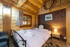 a bedroom with a bed in a wooden room at Zruby Vila Mária Vysoké Tatry in Otilia