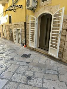 a building with open doors on the side of a street at Azzurra Holiday Home - Molfetta in Molfetta