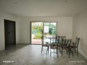 a dining room with a table and chairs and a window at 3 chambres en collocation ou maison entière in Colomiers