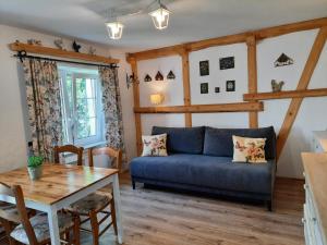 a living room with a blue couch and a table at Agroturystyka Kaczeniec in Ustronie Morskie