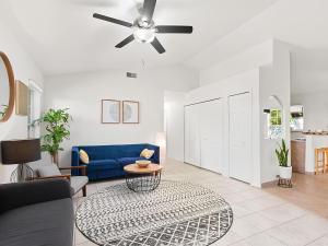 a living room with a blue couch and a ceiling fan at Anastasia Island Villa Upper Level plus Rooftop in St. Augustine