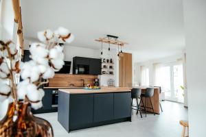 a kitchen with black cabinets and a kitchen island with stools at Duplex spacieux centre-ville de Spa in Spa