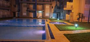 a swimming pool in the middle of a building at night at Sable d or saidia in Saïdia