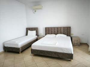 a bedroom with two beds and a lightswitch on the wall at Vila Andoni in Qeparo