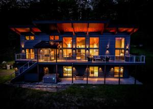 a large house at night with its lights on at 4BR - 2 Mstr Suites, Hot Tub, Prime Views, Privacy in Waitsfield