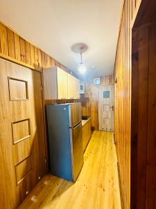 a kitchen with a refrigerator and wooden walls at ANELL Hostel in Poznań