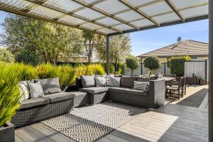 a patio with wicker couches and a table and chairs at Mountain View House in Cromwell