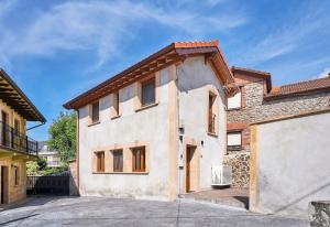 a large white house with a garage at Marismas - by Wehomes - casa in Pontejos
