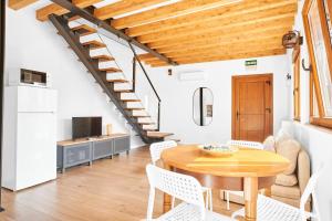 a kitchen and dining room with a wooden table and chairs at Marismas - by Wehomes - casa in Pontejos