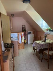 a kitchen with a table and a kitchen with a staircase at Lilla Apartman in Sárvár