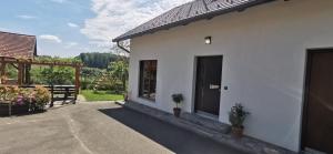 une maison blanche avec une porte et un patio dans l'établissement Apartment Ratek, à Ivanjkovci