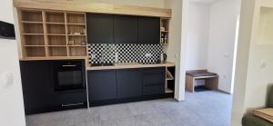 - une cuisine avec des armoires noires et une cuisinière dans l'établissement Apartment Ratek, à Ivanjkovci 8 autres photos