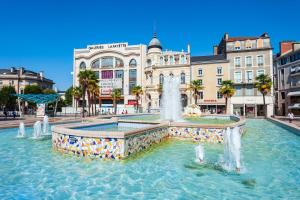 a fountain in the middle of a city with buildings at Charmant T3 centre Pau - Balcon in Pau