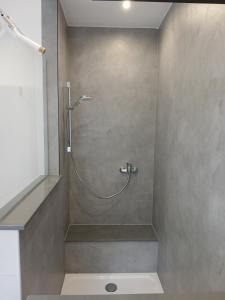 a shower with a hose in a bathroom at Sarah's apartment NEW! in Mendig
