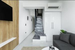 a living room with a couch and a staircase at kallithea maisonette in Kallithea Halkidikis