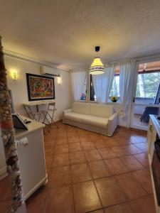 a living room with a couch and some windows at Bilocale presso Costa Smeralda in Cugnana Verde