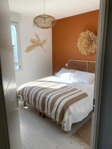 1 dormitorio con 1 cama con paredes de color naranja en Appartement cosy 2 ch avec toit terrasse & parking - Lumineux et calme, en Les Sables-dʼOlonne
